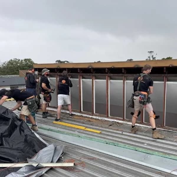The Strata Remedial Services crew repairing a metal roof and parapet screen